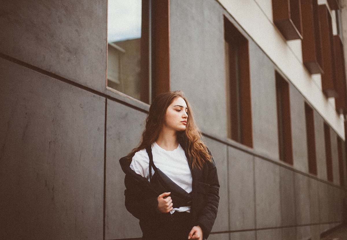 human woman standing beside gray building people