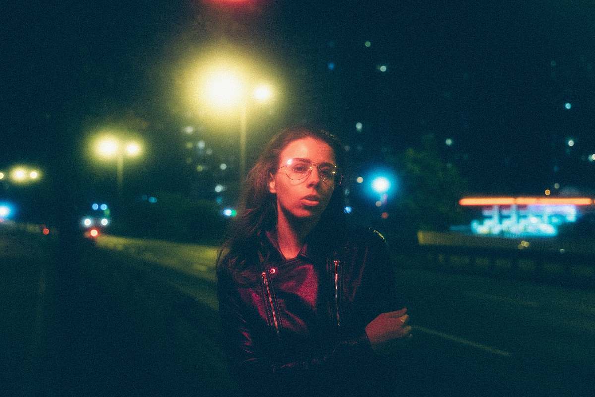 human woman standing near street light during night time lighting