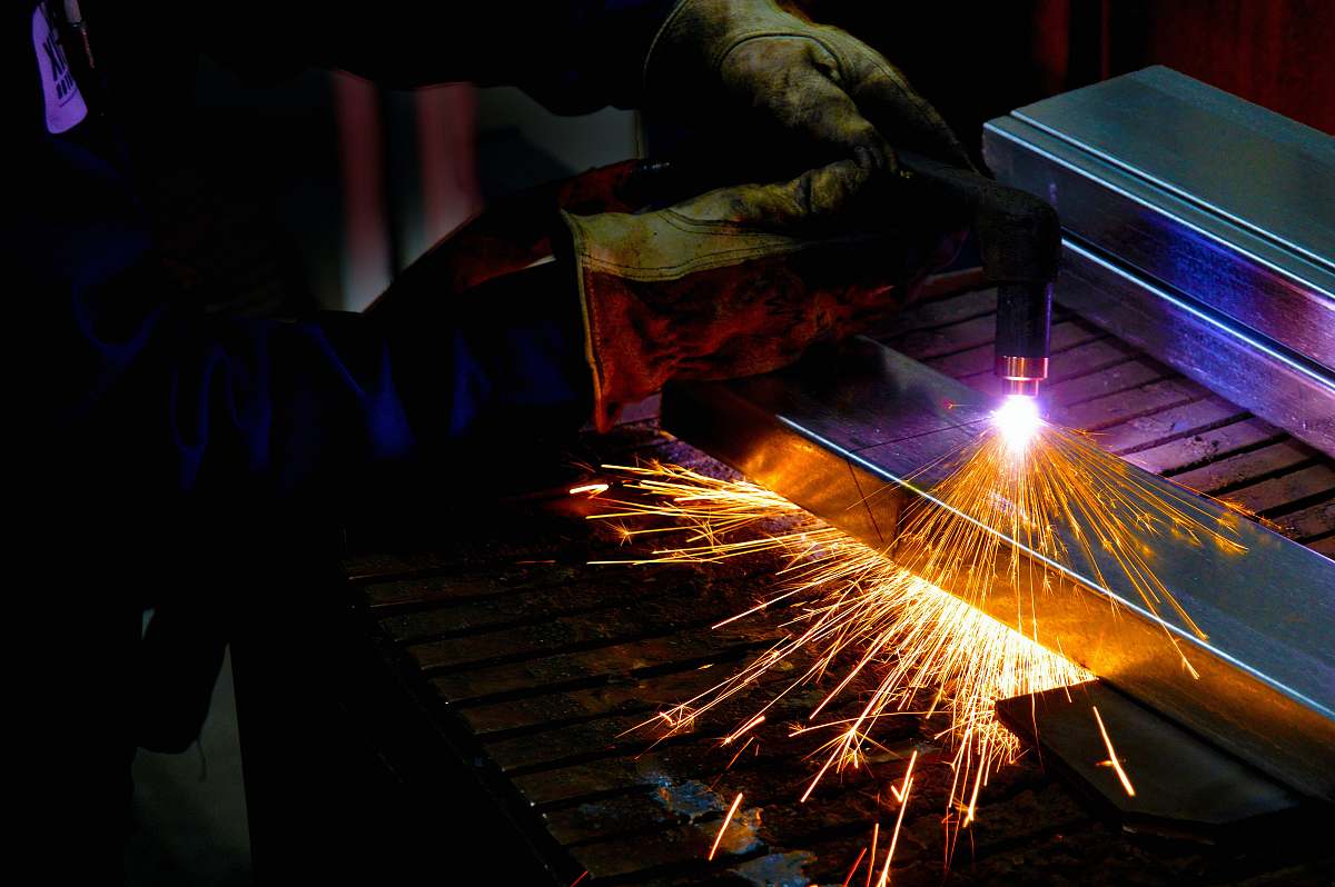 light man holding welding torch sparks