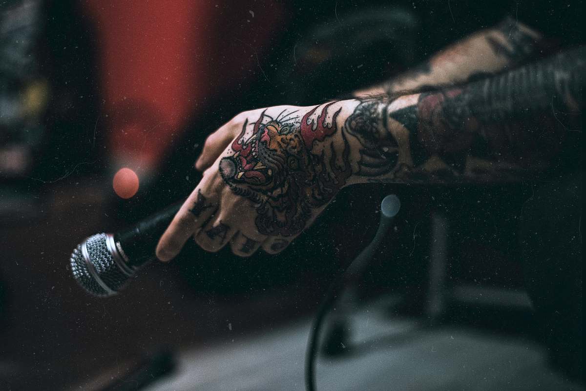 microphone tattooed person holding microphone singer