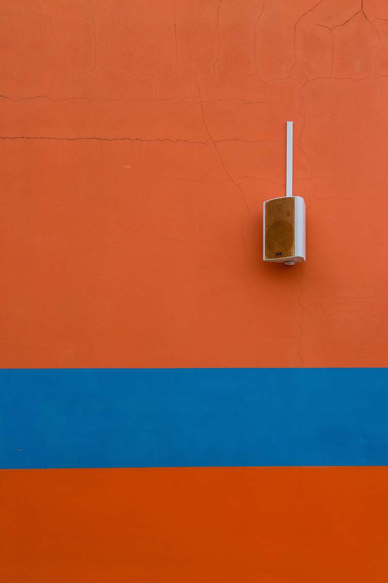 speaker white speaker mounted on orange painted wall adapter
