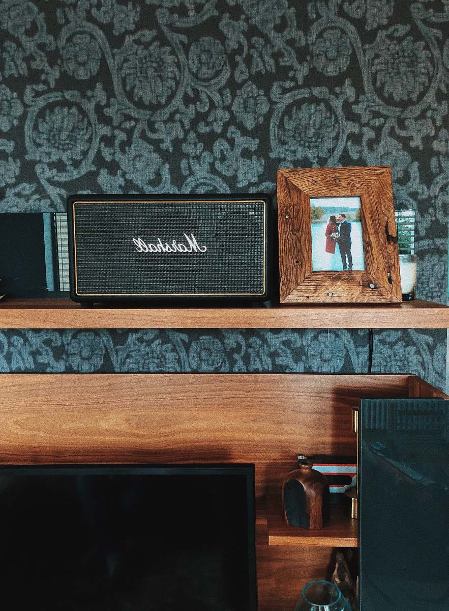 hardwood black Marshall speaker beside photo frame plywood