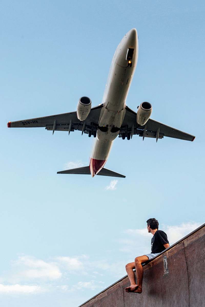 person low angle photography of man wearing black shirt under white and gray airplane people