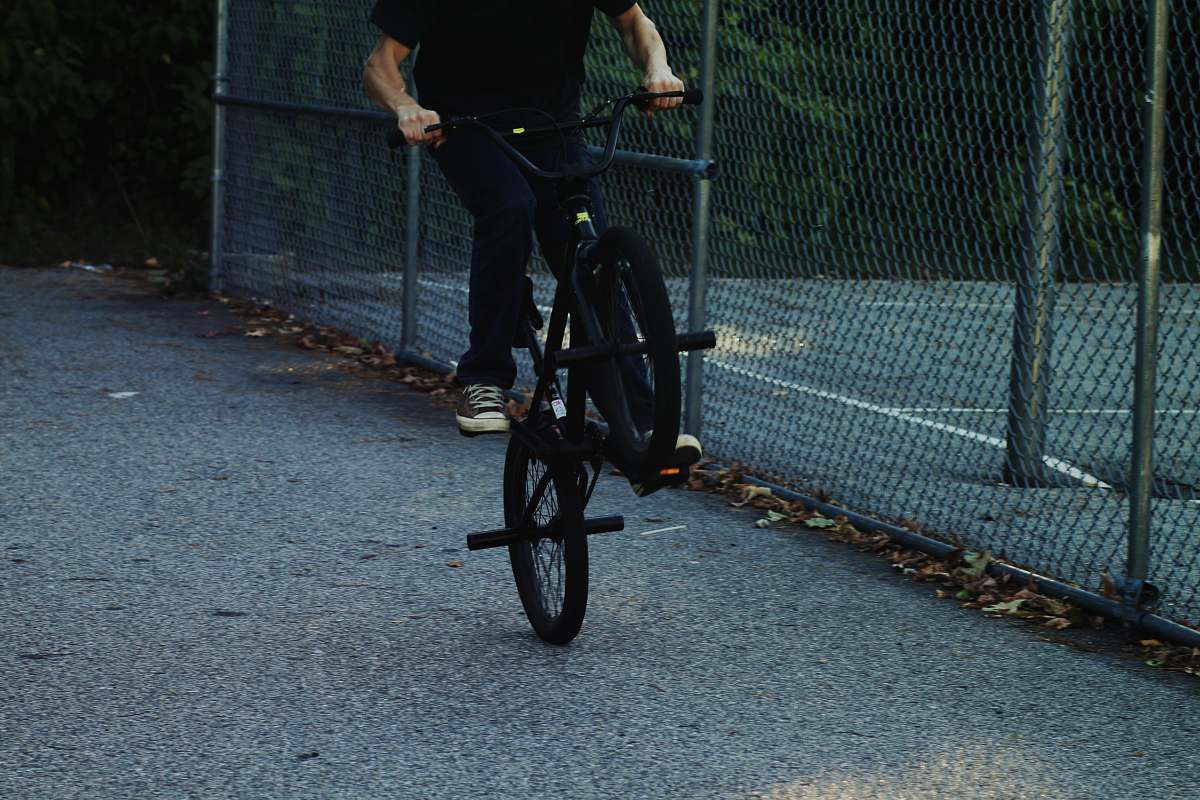 bike person riding BMX bike near chain link fence bmx