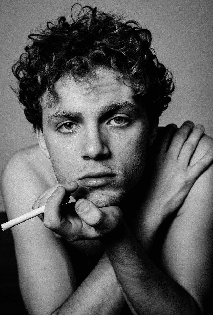 people gray scale photo of man holding cigarette portrait