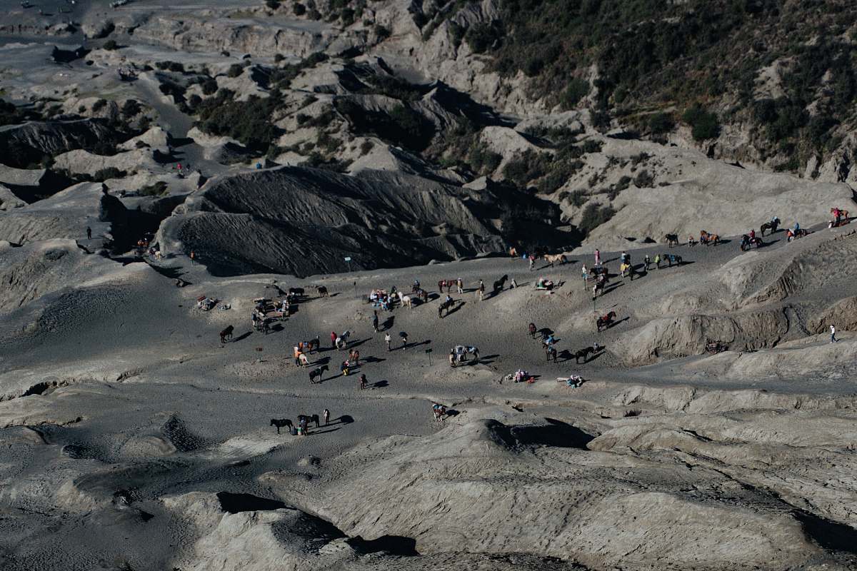 indonesia aerial photography of people standing on gray rocky mountain during daytime mount bromo