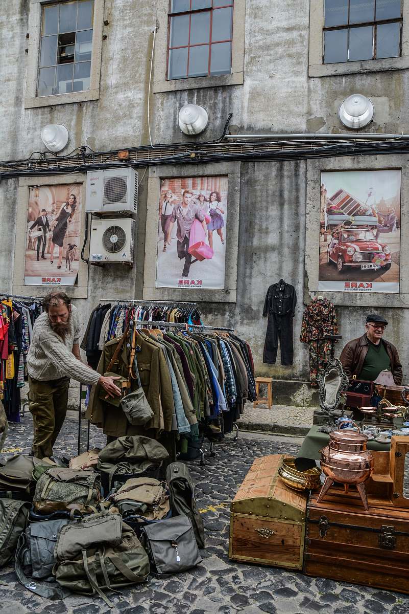 human clothes and bags displayed on road near building during daytime person