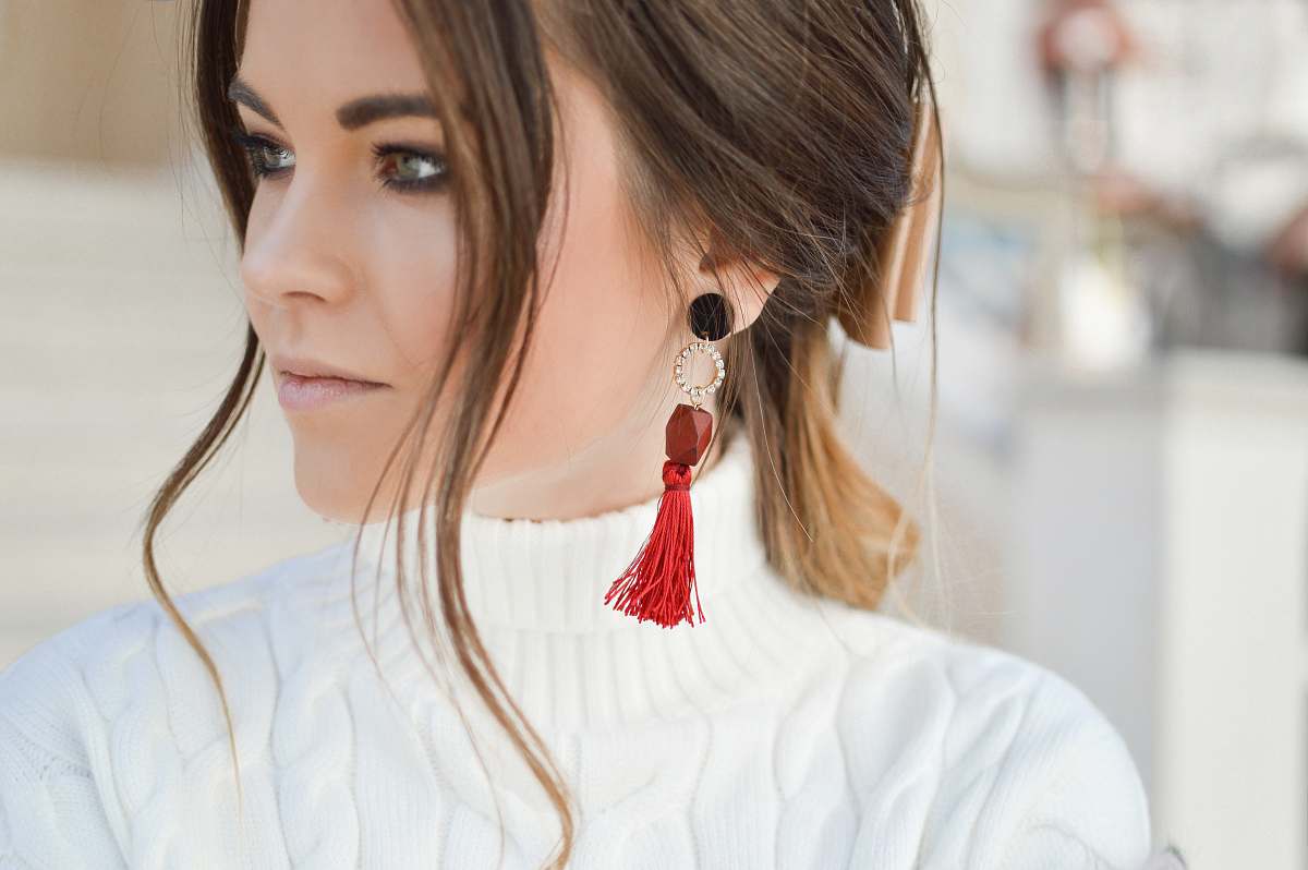 person focus photography of woman wearing red tassel earrings while looking on her left side human
