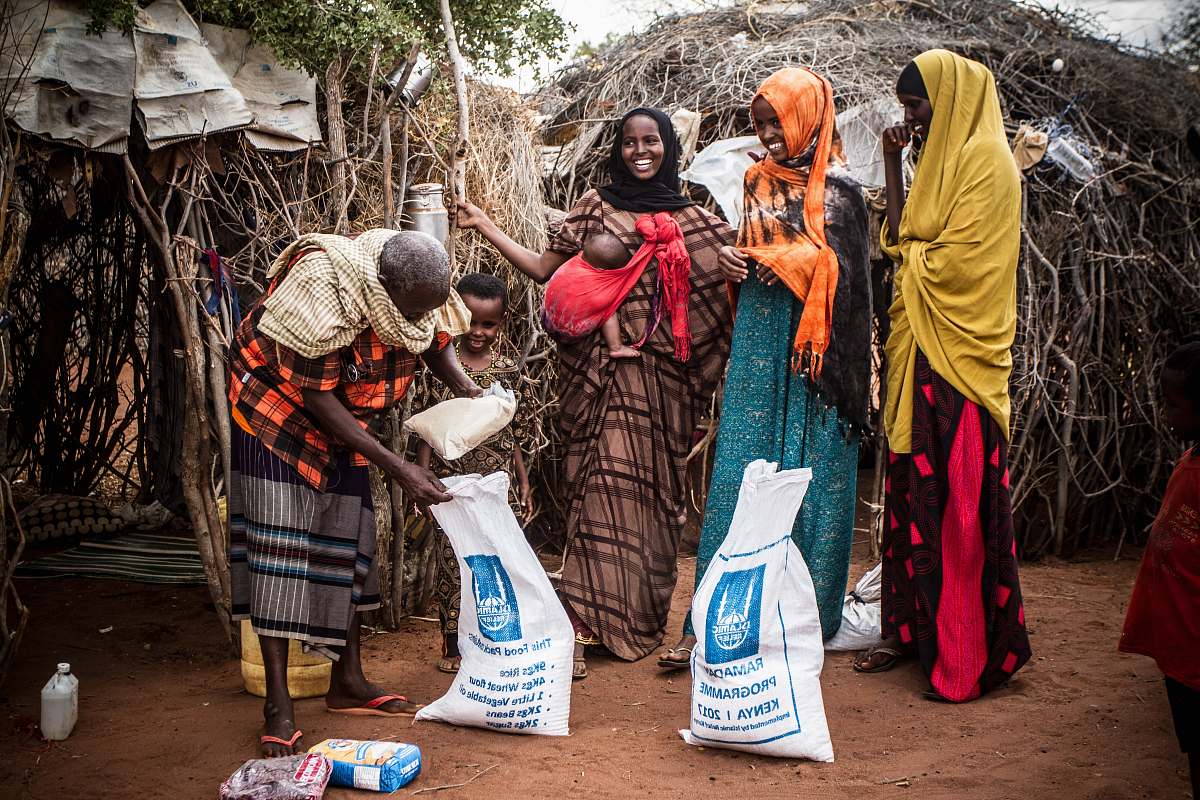 person four women standing near white-and-blue sack outdoor human