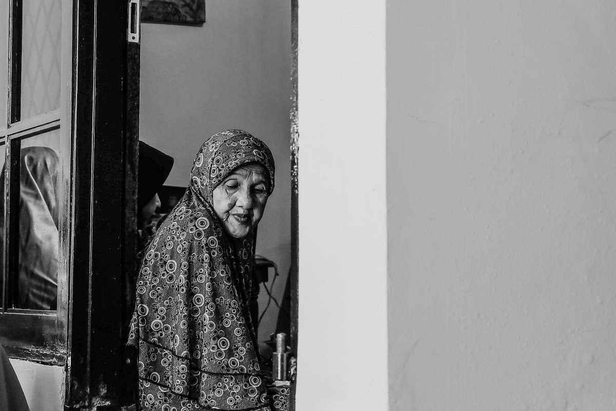 person grayscale photo of woman between doors black-and-white