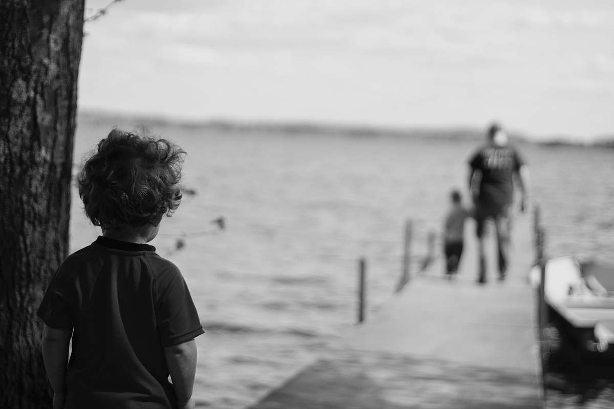 black-and-white grayscale photography of child beside tree grey