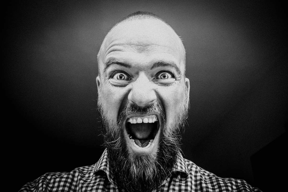 human grayscale photography of man opening his mouth black-and-white