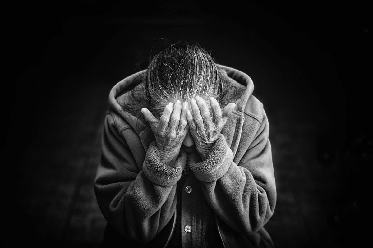 human grayscale photography of person covering face black-and-white