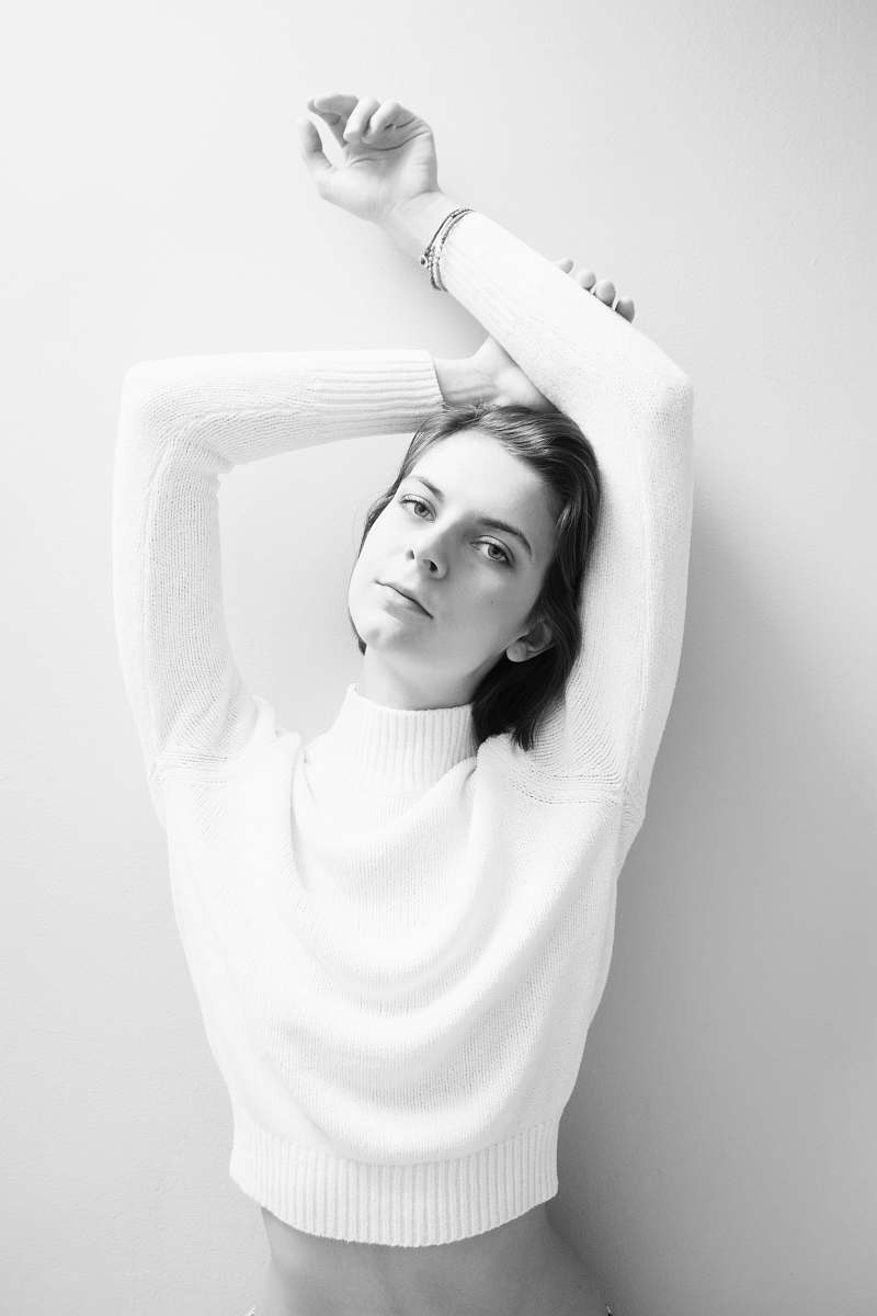 black-and-white grayscale photography of woman leaning on wall portrait