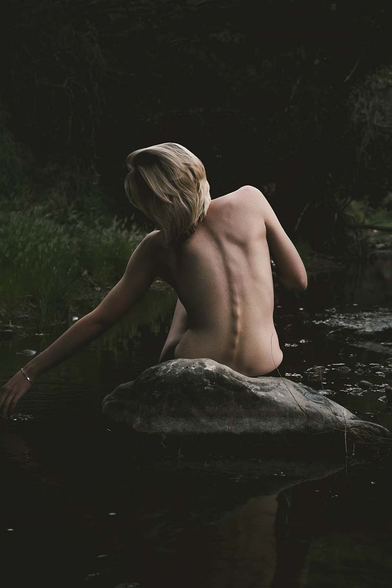 human half naked woman sitting on rock woman