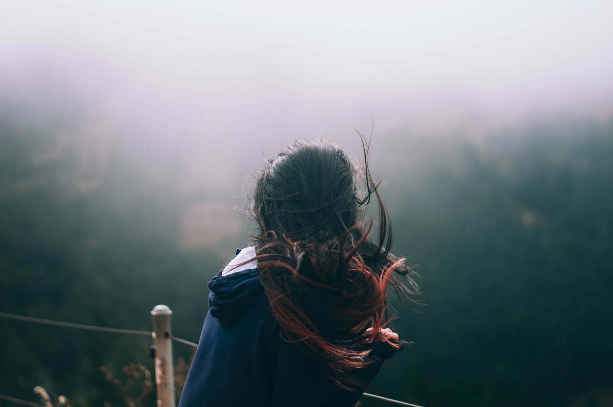 person landscape photography of woman standing in front of trees woman
