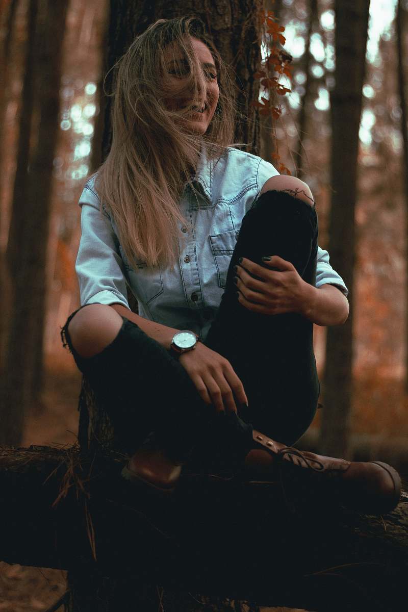 person laughing woman leaning on gray tree trunk human
