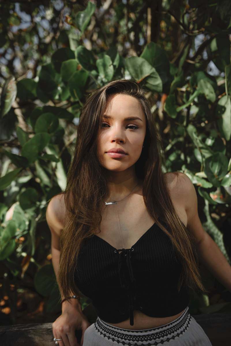 person lowlight photography of woman in black crop top near plants girl