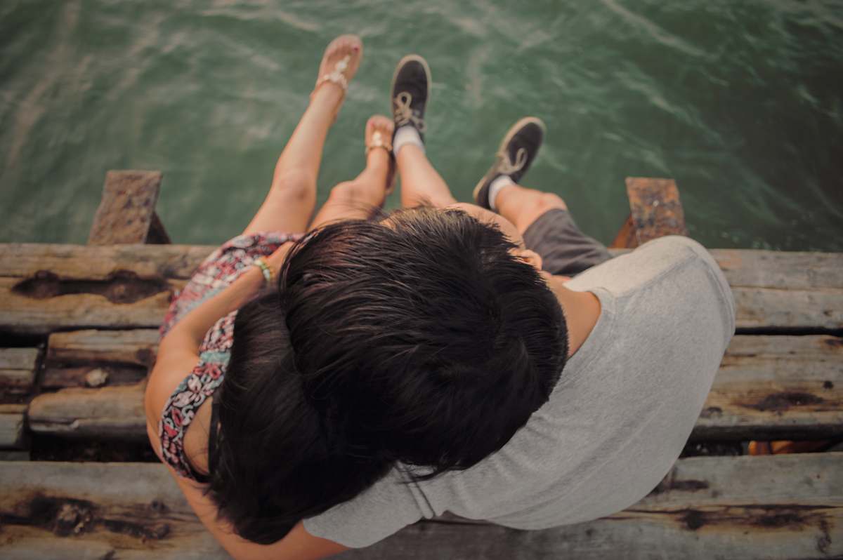 couple man and woman hugging each other on brown wooden dock love