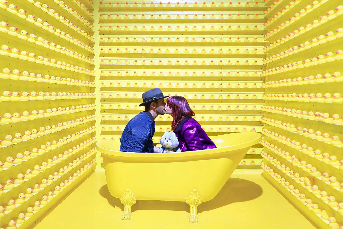 person man and woman kissing inside yellow bathtub human