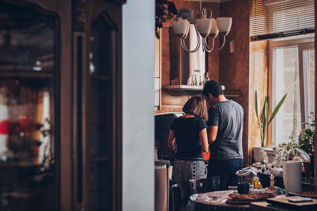 food man and woman standing in front of gas range pottery