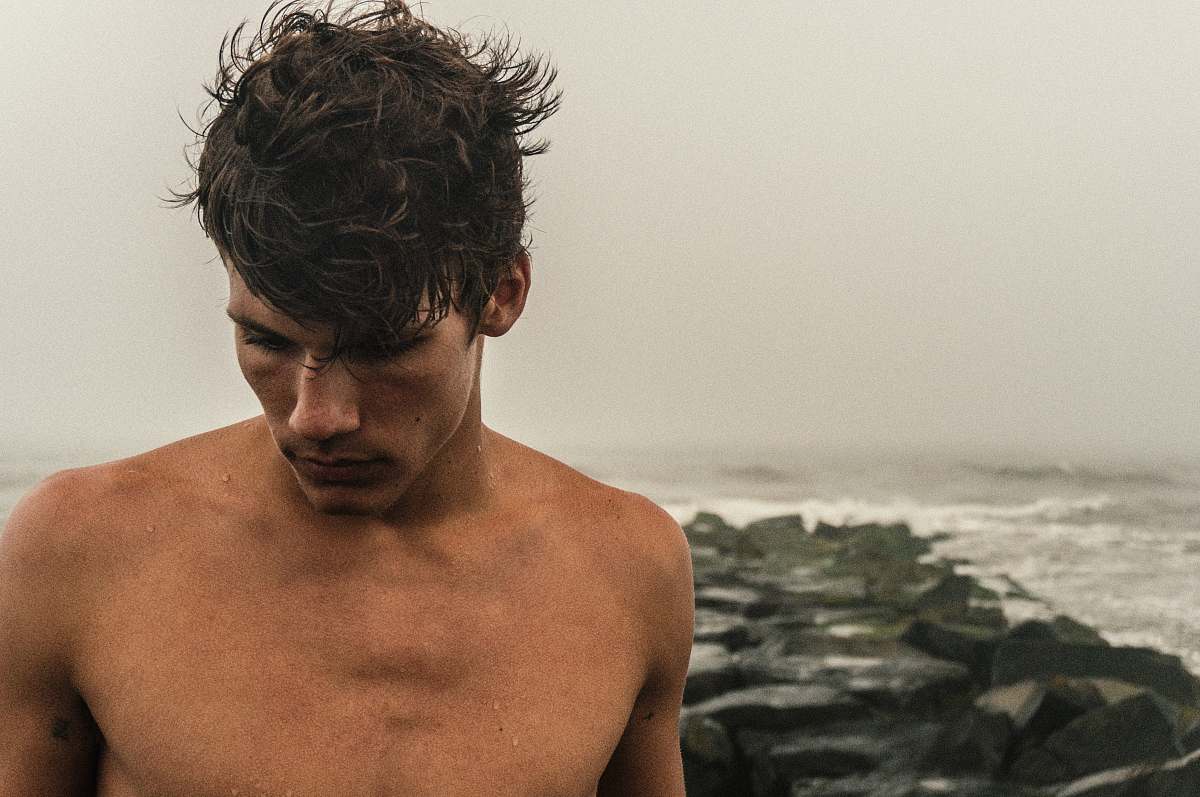 person man behind sea during daytime human
