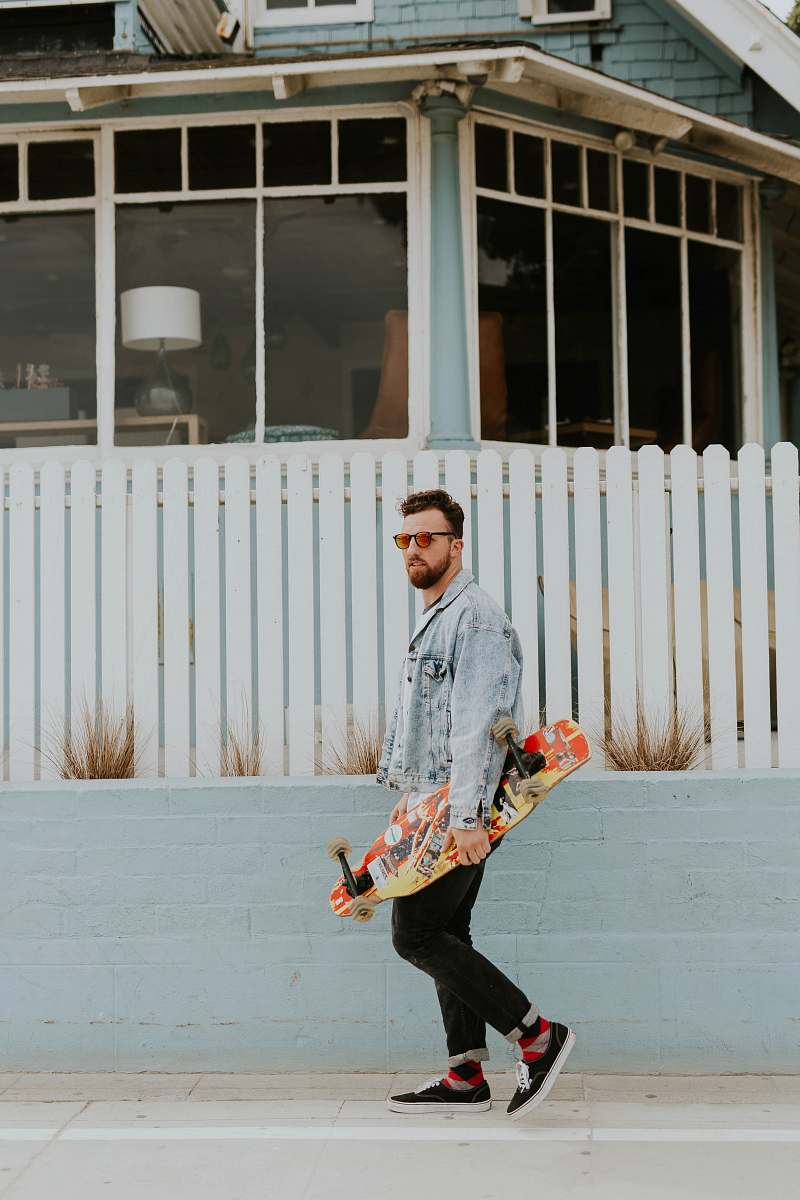 person man holding longboard skateboard