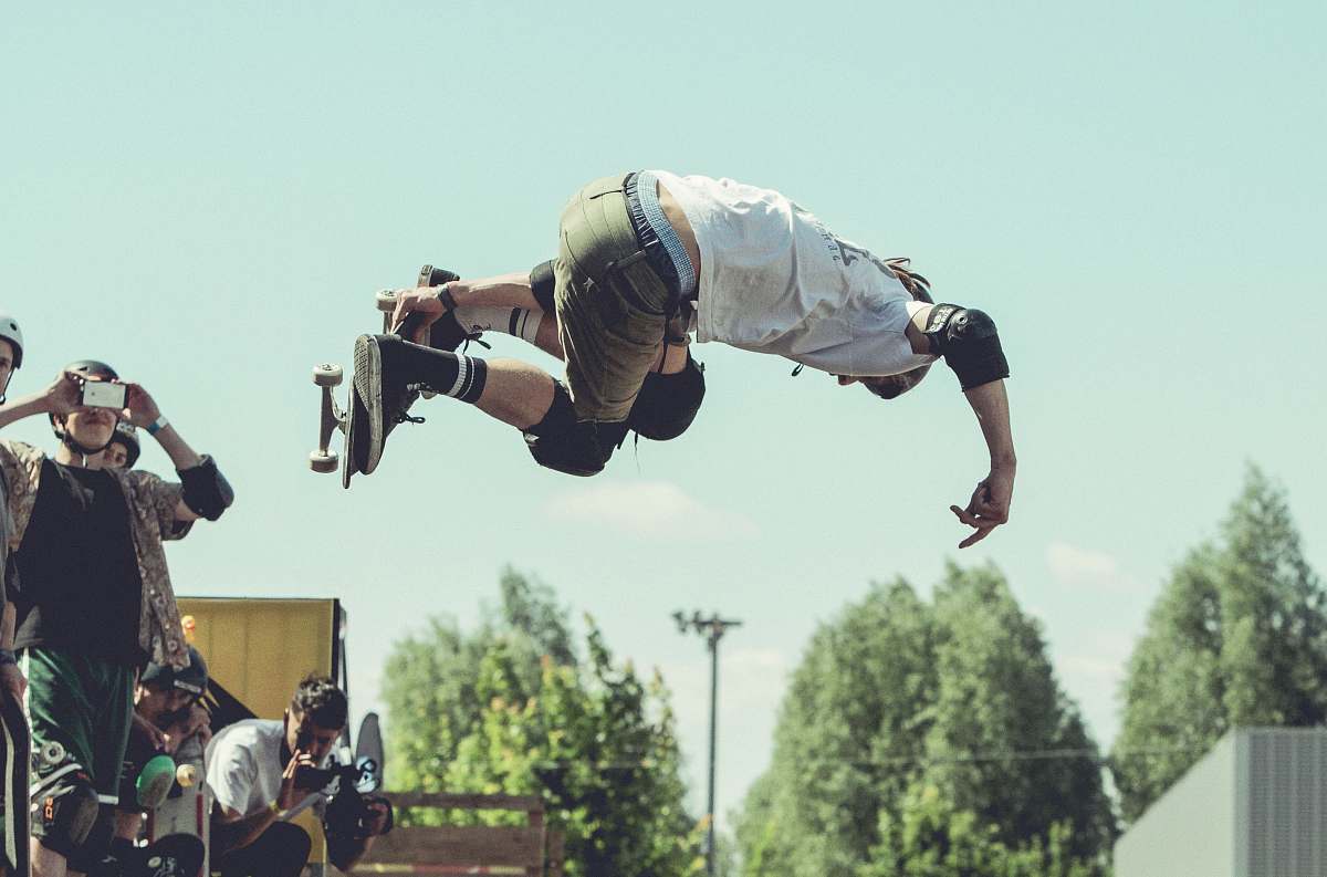 person man holding skateboard while doing tricks during daytime human