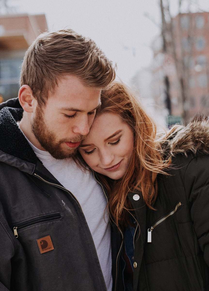 human man hugging woman standing on road person