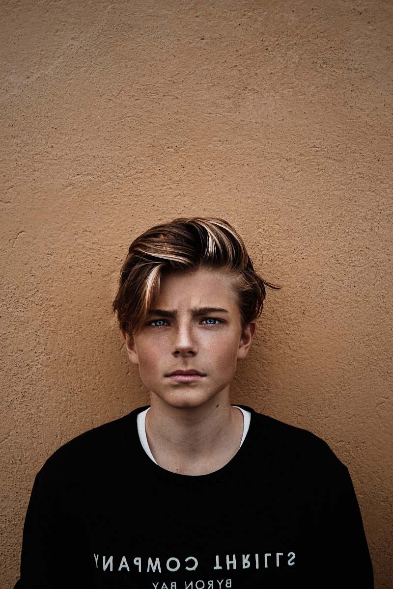 human man in black crew-neck shirt near brown wall person