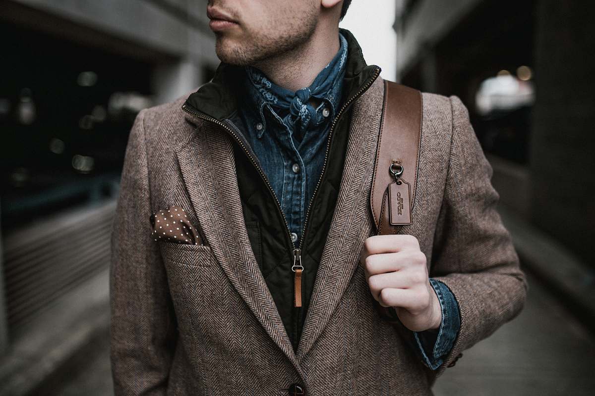 person man in brown suit jacket carrying brown backpack human