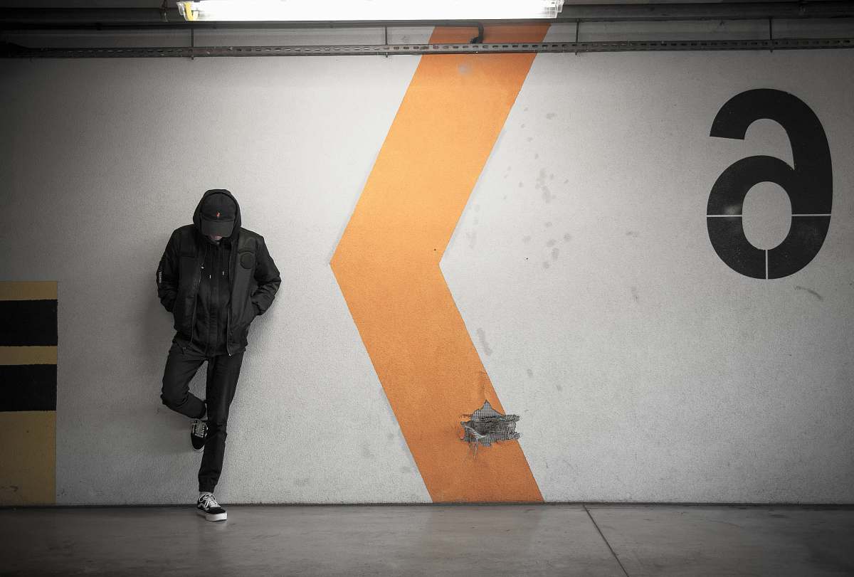 person man leaning on white wall of the parking area urban