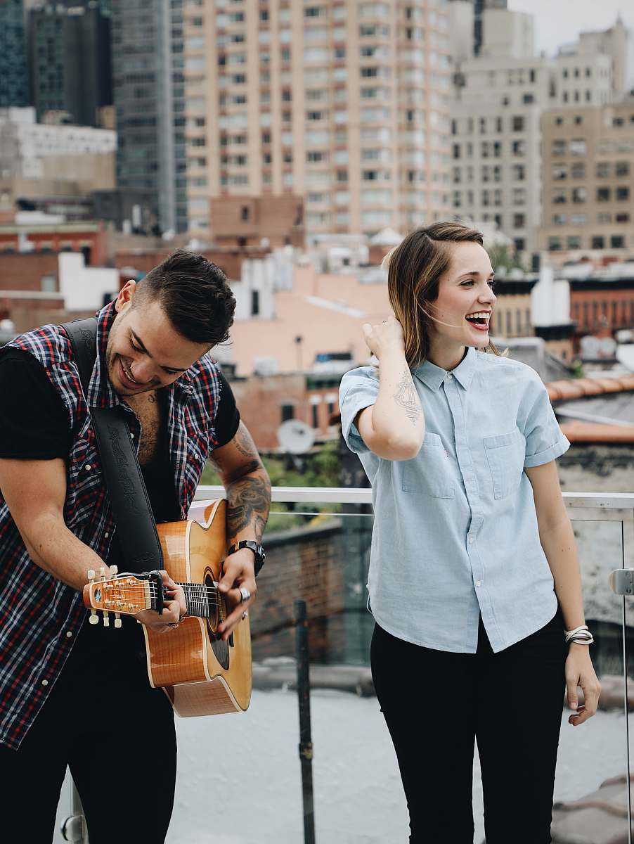 person man playing guitar beside singing woman music