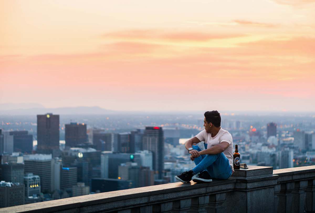 person man seating beside buildings city