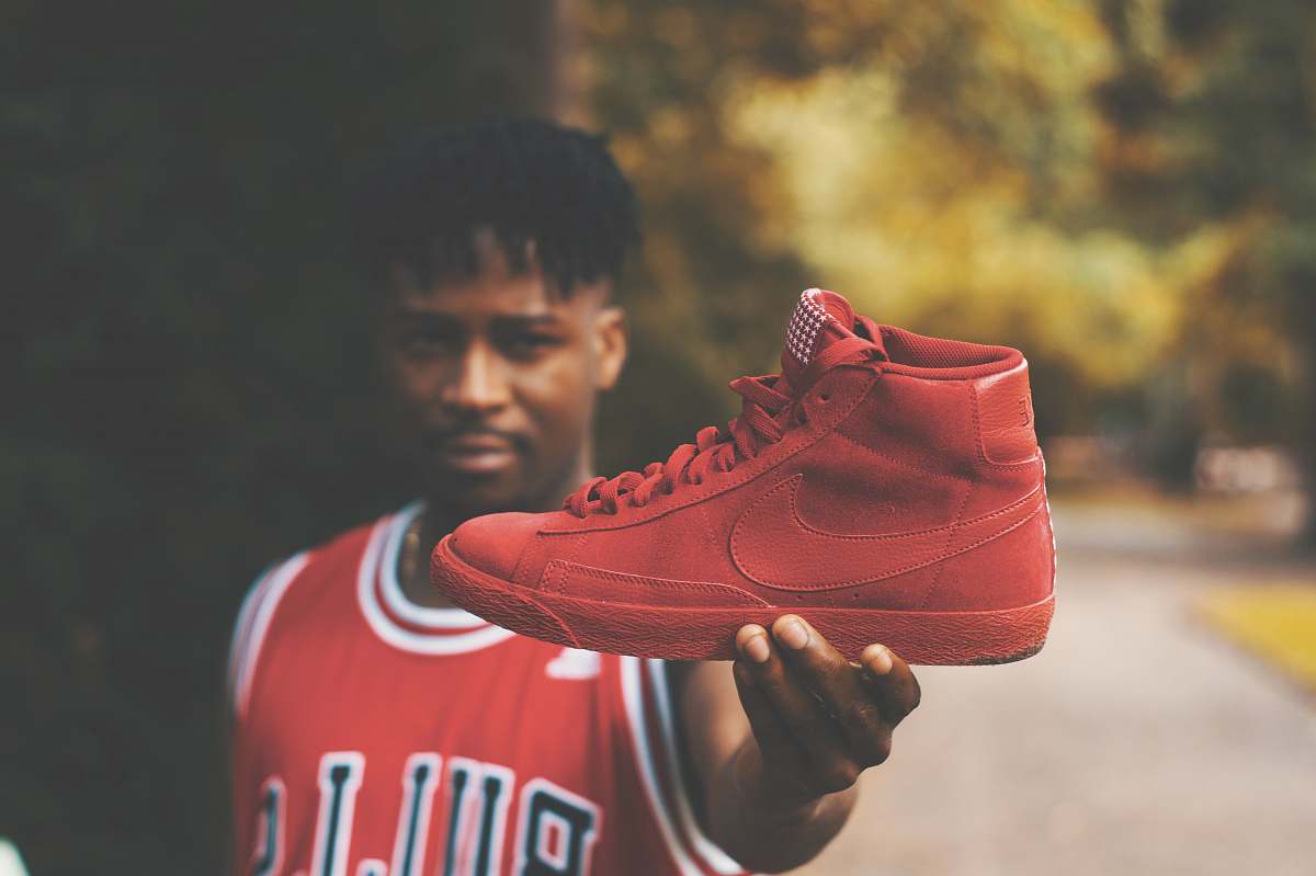person man showing red Nike high-top sneaker shoe