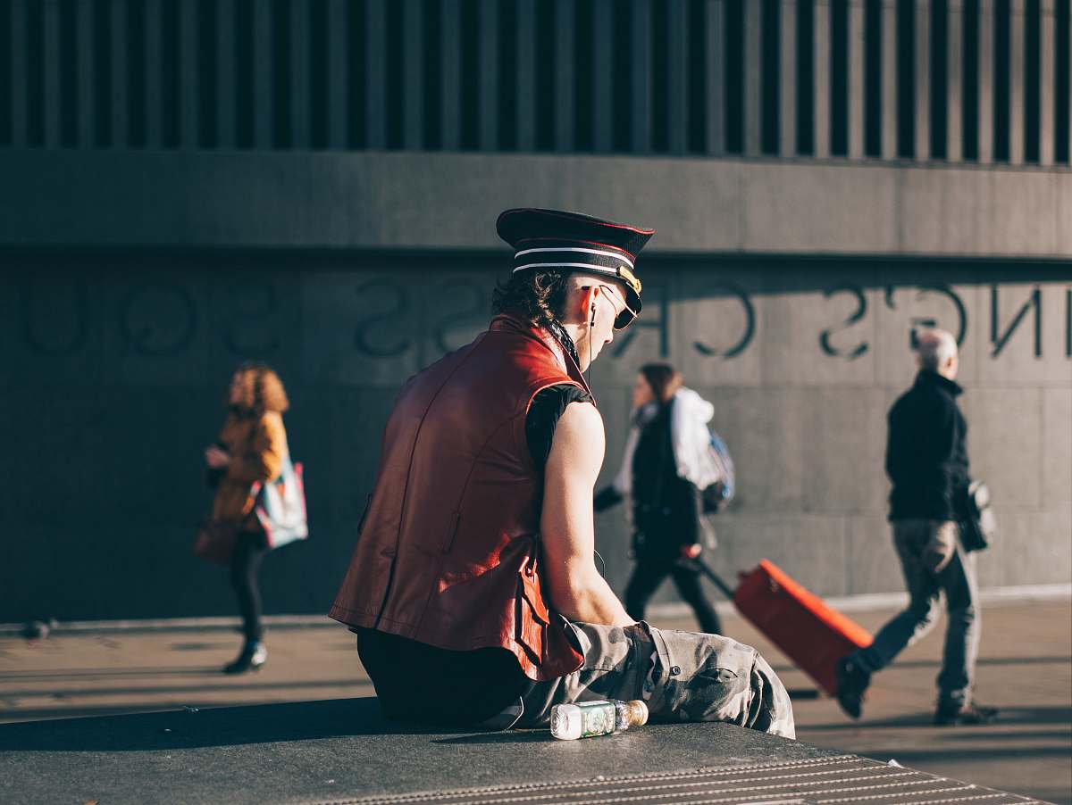 person man sitting on pavement man