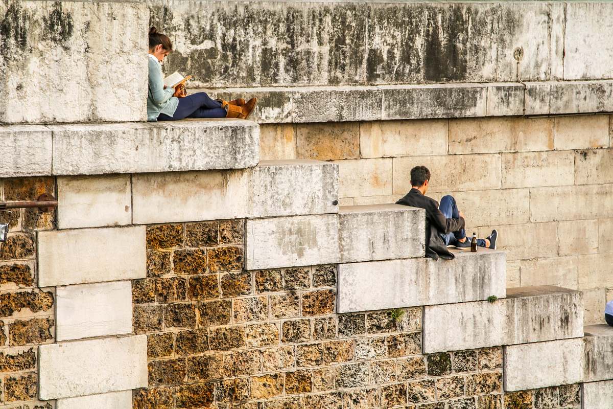 paris man sitting on staircase behind woman sitting on highest staircase france
