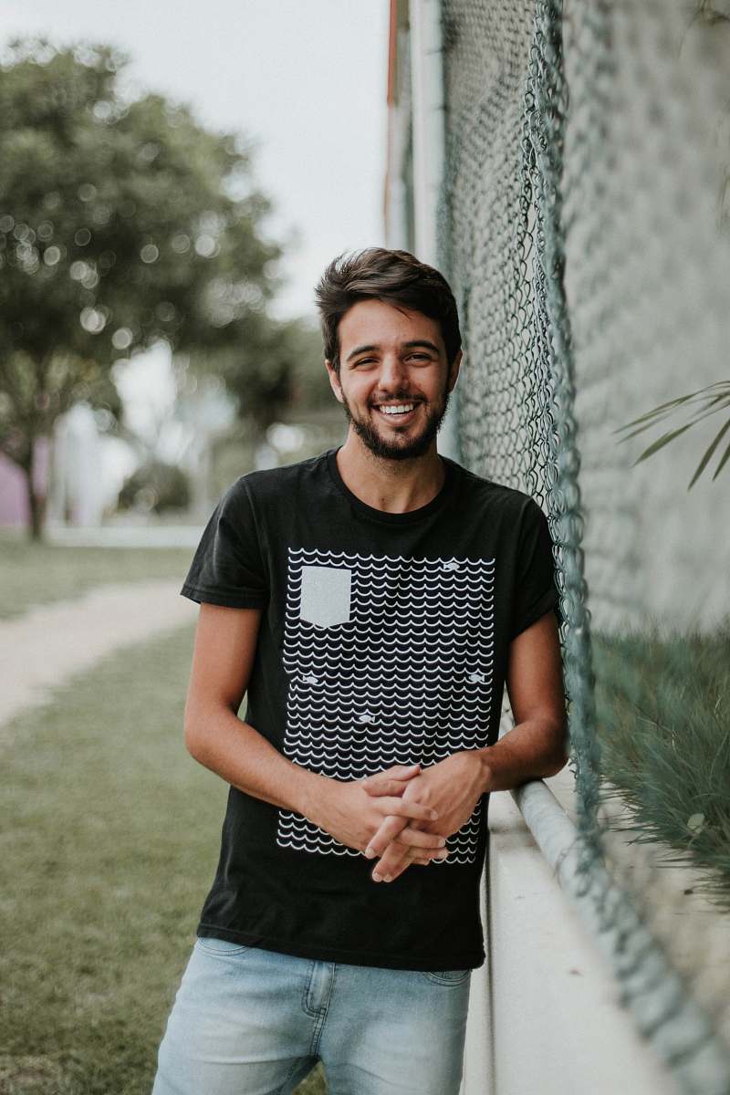 person man standing beside metal fence human