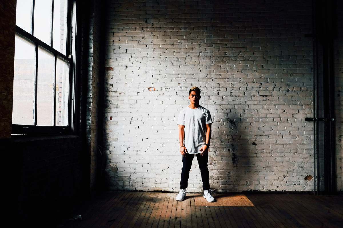 person man standing in front of white wall human
