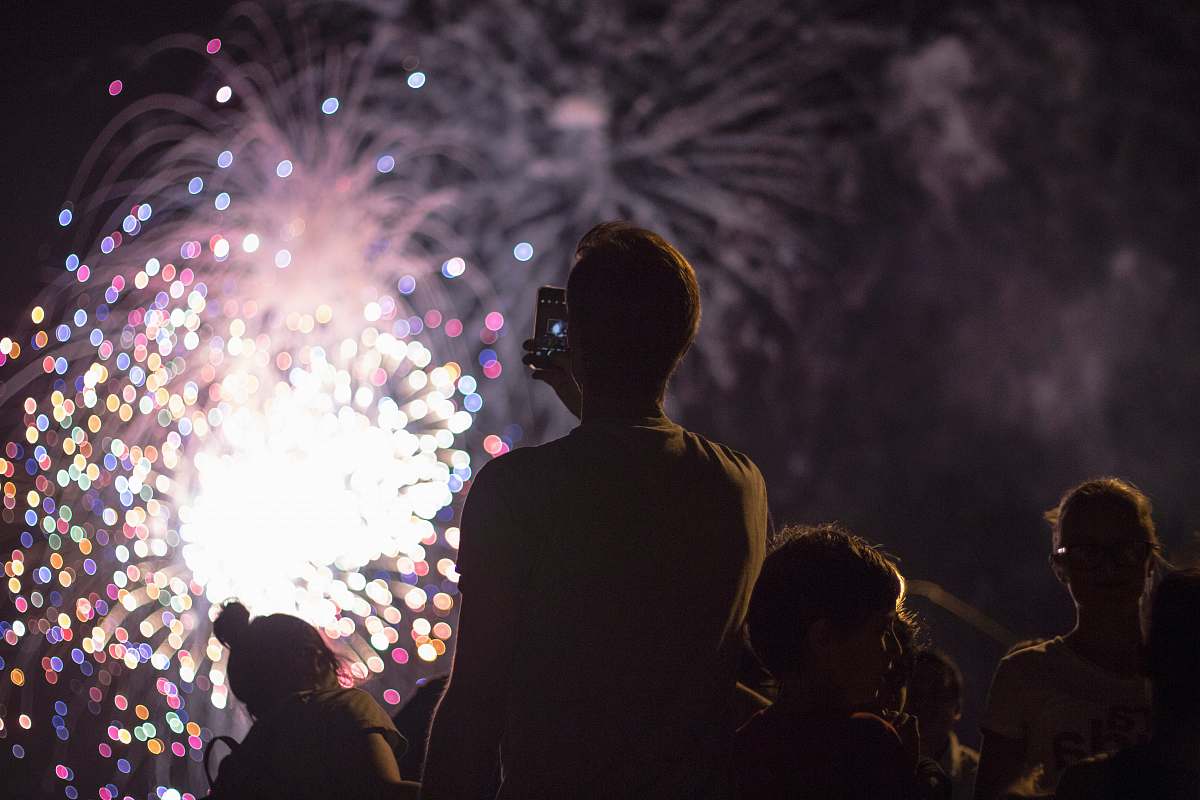 fireworks man taking picture of firecracker night