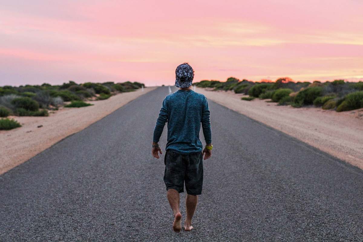 person man walking on gray concrete road road