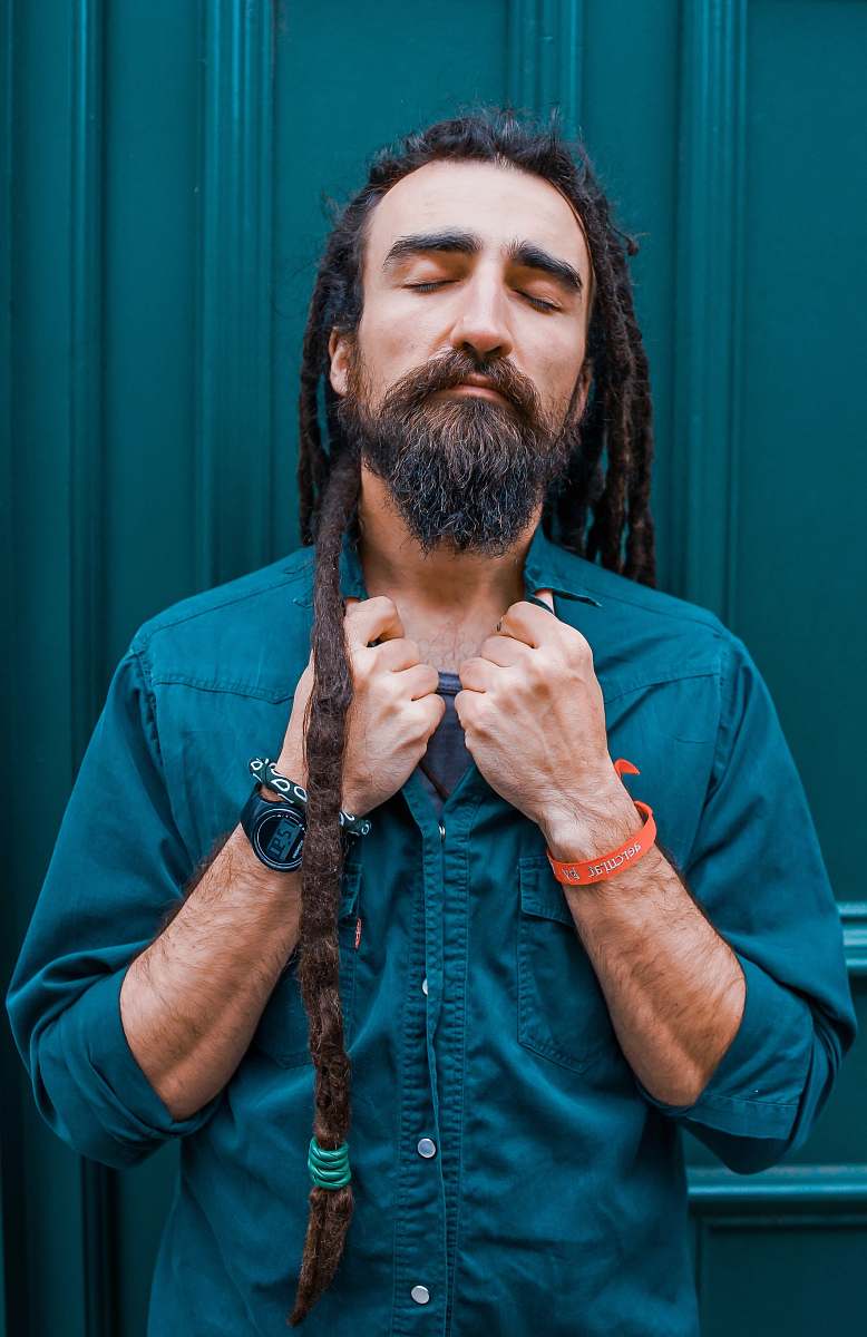 person man wearing green dress shirt holding his collar human