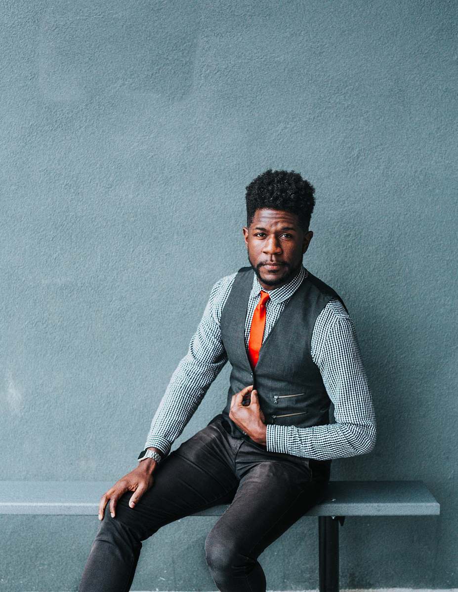 person man wearing vest sitting on bench human