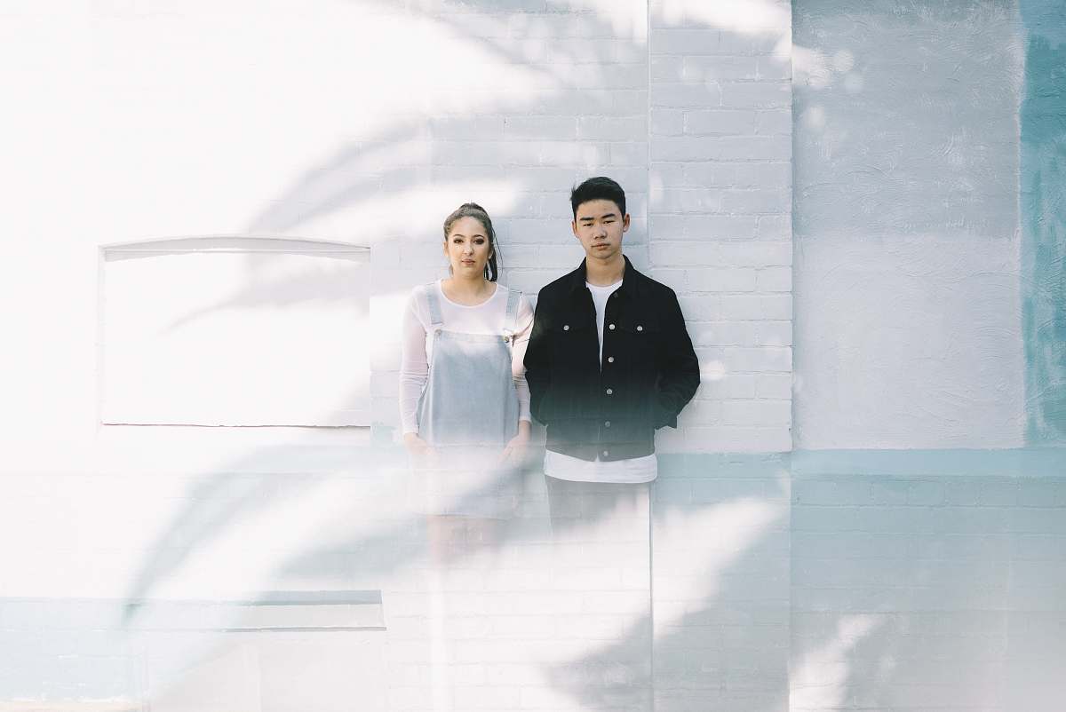 person minimalist photography of man beside woman while leaning against wall human
