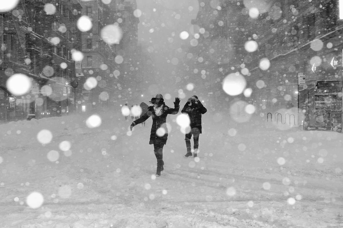 black-and-white people walking on snow covered street with bokeh effects photo winter