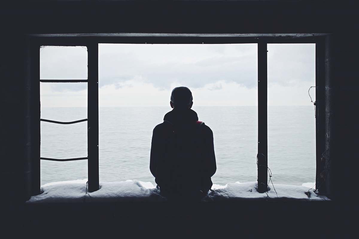 person person looking out through window silhouette
