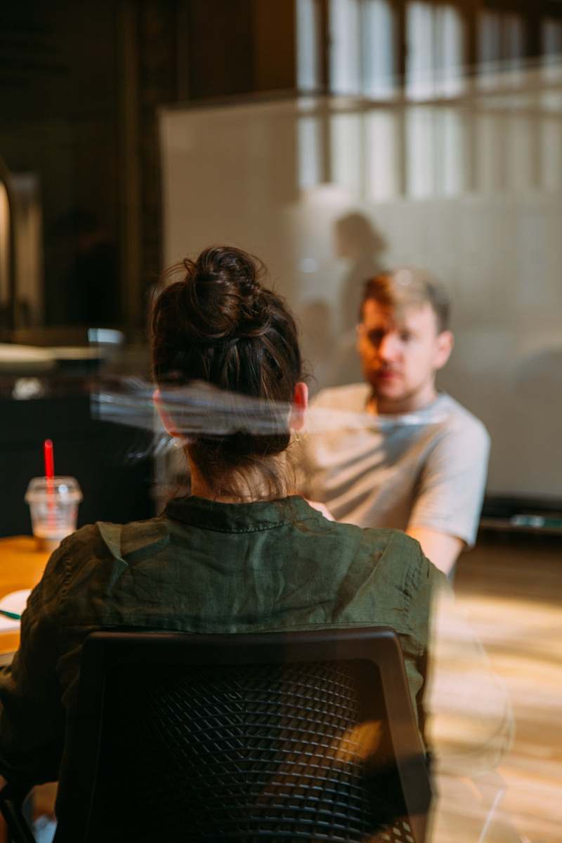 person person sitting in a chair in front of a man human