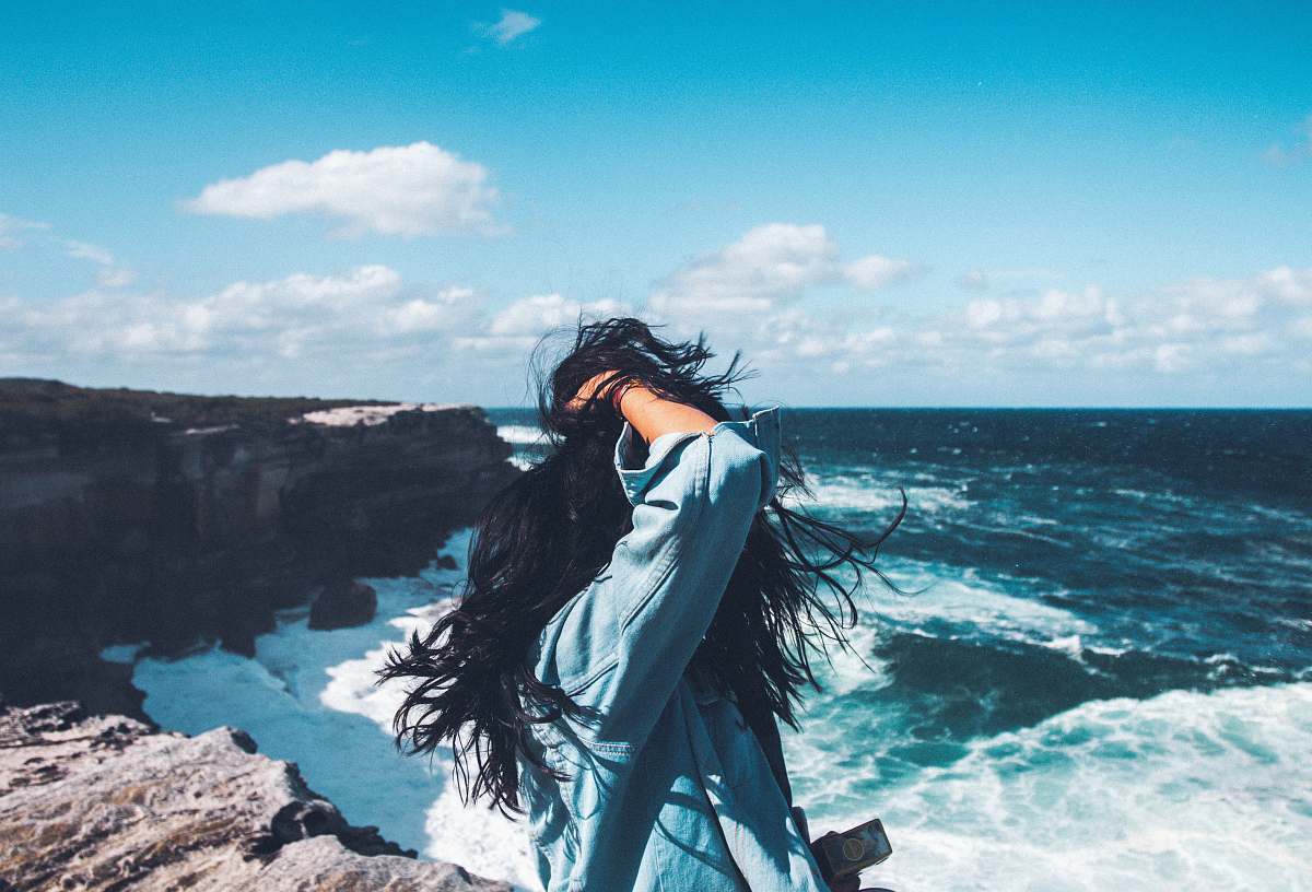 person person standing in front of body of water during daytime woman