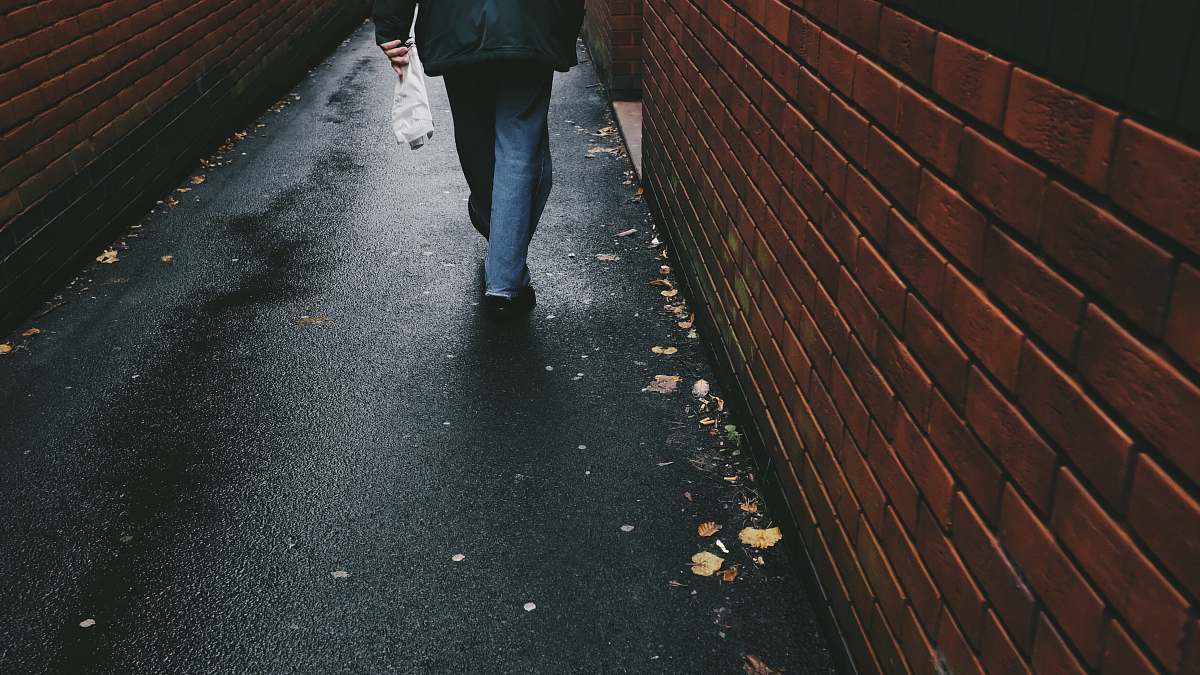 person person walking on black-paved alley human