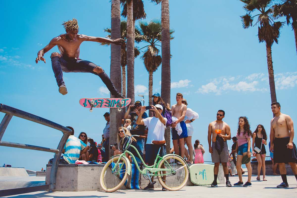 person person watching man using skateboard doing tricks during daytime bike